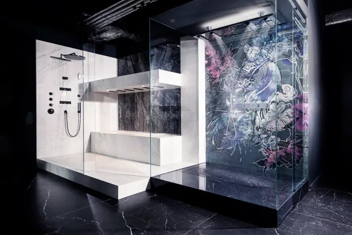 Showroom mit begehbaren Duschkabinen aus Glas und Marmor vor einer Wandgrafik