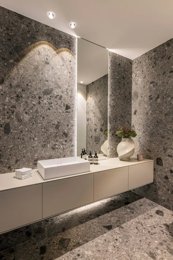 Badezimmer mit großformatiger Terrazzo-Wand, Spiegelband und schwebendem Waschtisch