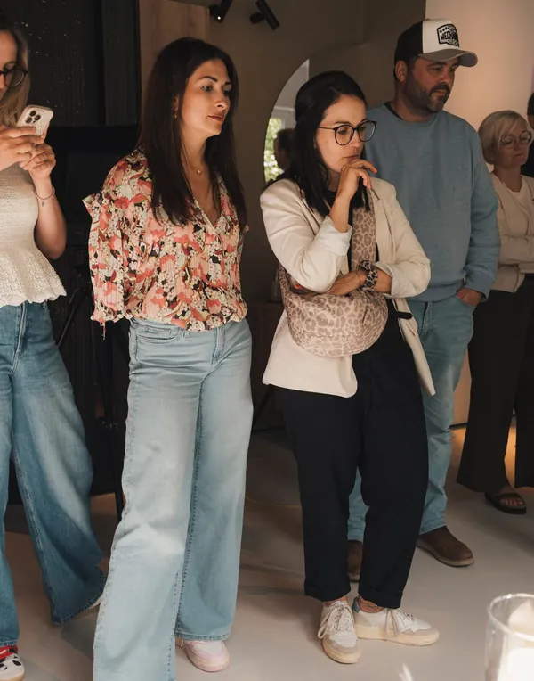 Teilnehmende stehen im Showroom, eine fotografiert mit dem Smartphone